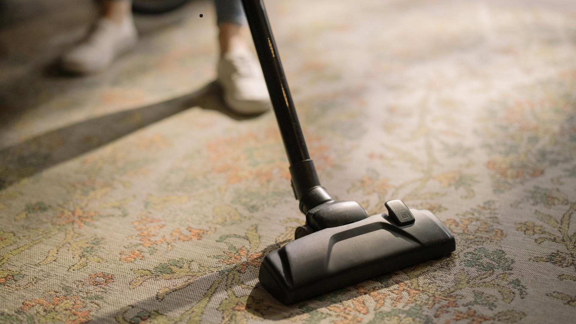 A vacuum cleaner nozzle cleaning a patterned rug, representing technology-driven innovation in smart home cleaning solutions, with a focus on automation and smart rugs for modern households.