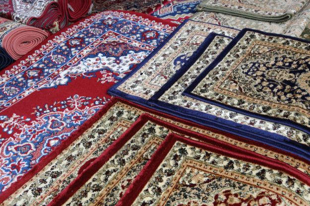 A collection of traditional rugs in various patterns and vibrant colors, including red, blue, and beige tones. The rugs display intricate floral and geometric designs, highlighting the detailed craftsmanship and variety of styles commonly found in classic rug collections.






