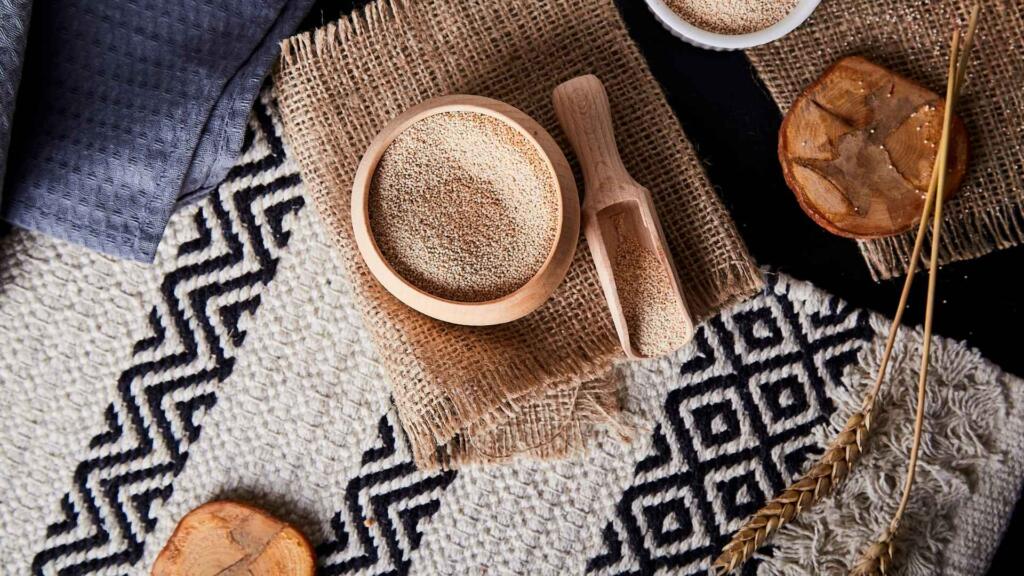 A textured patterned rug used as a backdrop, showcasing earthy tones and natural elements such as wooden bowls, burlap, and dried botanicals.