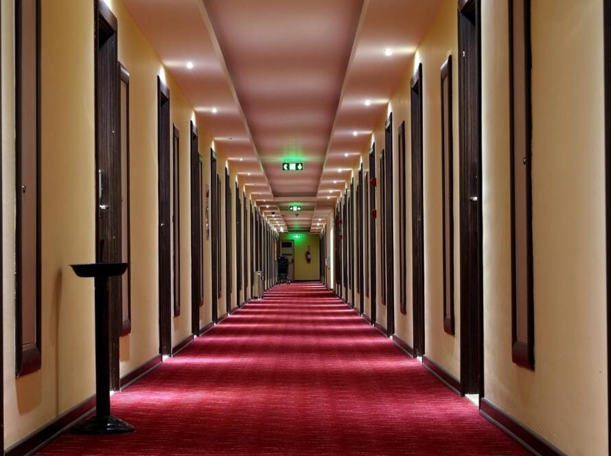 A luxurious hotel hallway featuring a red carpet, highlighting the importance of selecting the right hotel carpet supplier for a sophisticated and durable design