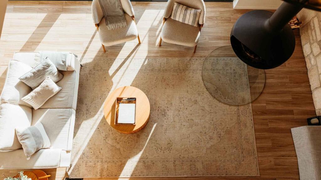 Handwoven rug complementing a cozy living room with armchairs and a fireplace.