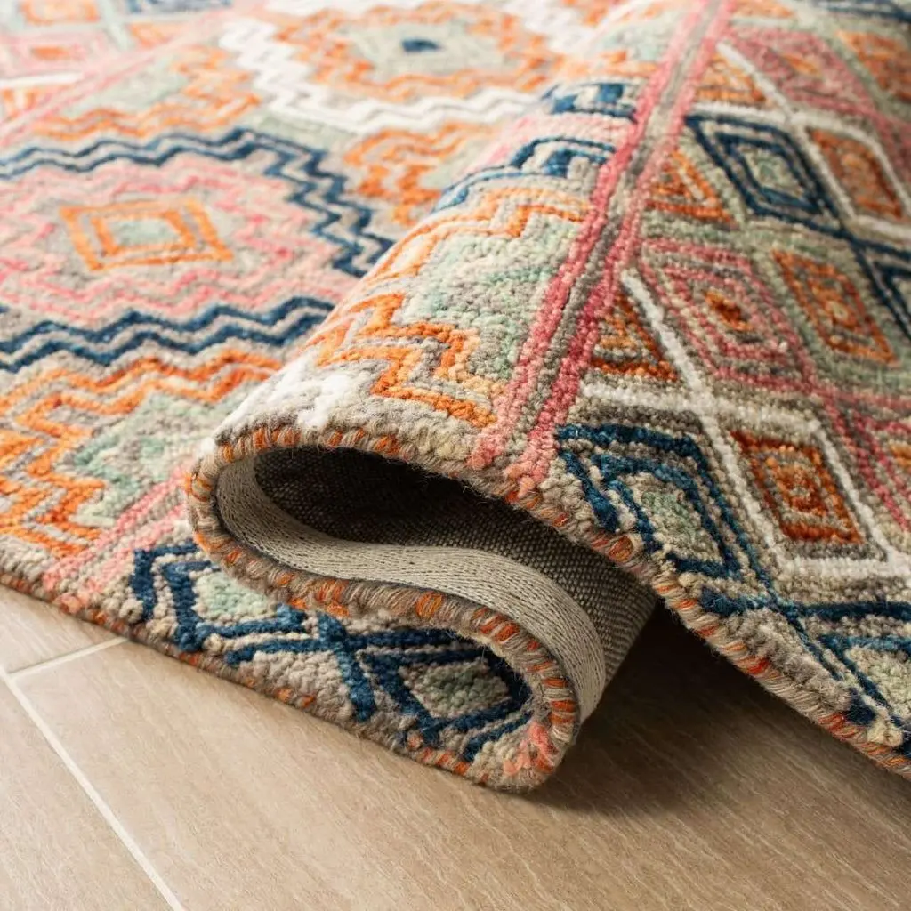 A folded rug with bold geometric shapes and vibrant colors such as orange, pink, and blue, showing its thick pile and textured edges.